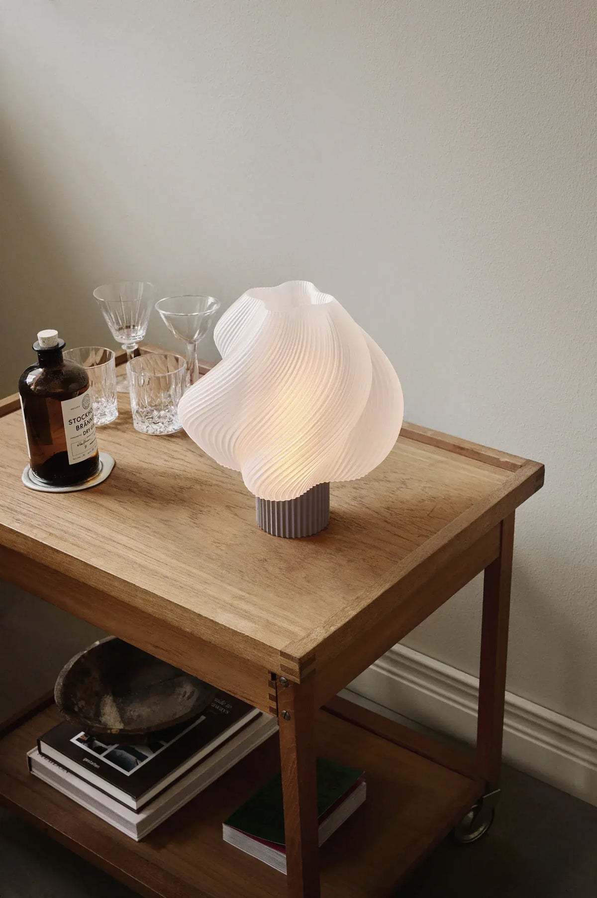 Lampe de table Soft Serve Mocha allumée sur une table en bois