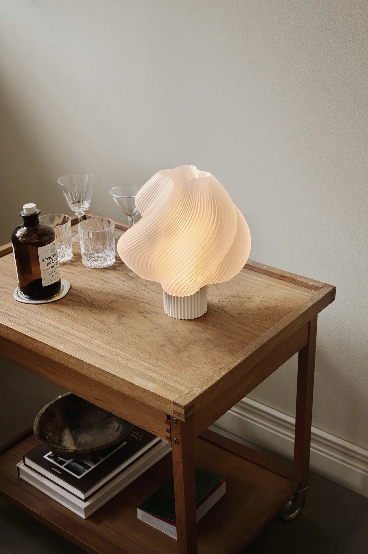 Lampe de table Soft Serve Vanilla Bean allumée sur une table en bois