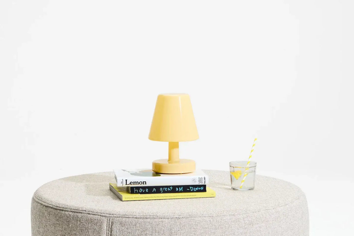 Lampe Fatboy the Ambiance jaune sur un pouf