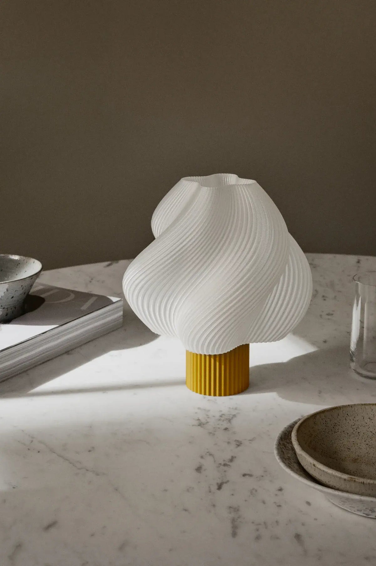 Lampe portable Soft Serve Cloudberry de Crème Atelier posée sur une table en marbre