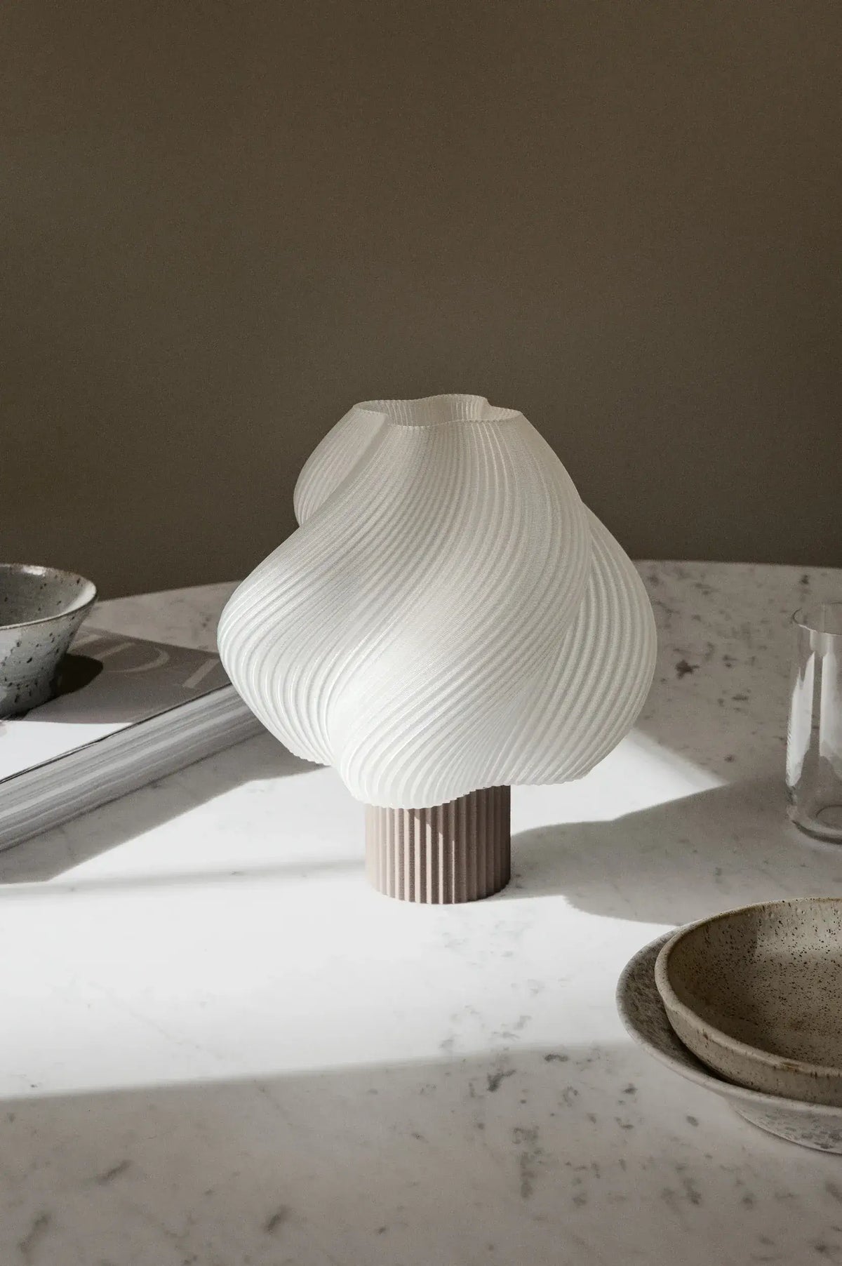 Lampe portable Soft Serve Mocha de Crème Atelier sur une table en marbre