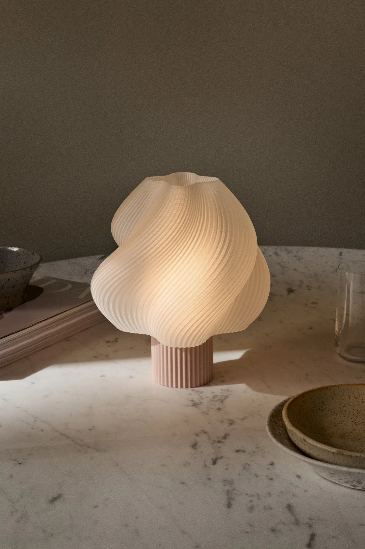 Lampe portable Soft Serve Wild Strawberry allumée sur une table