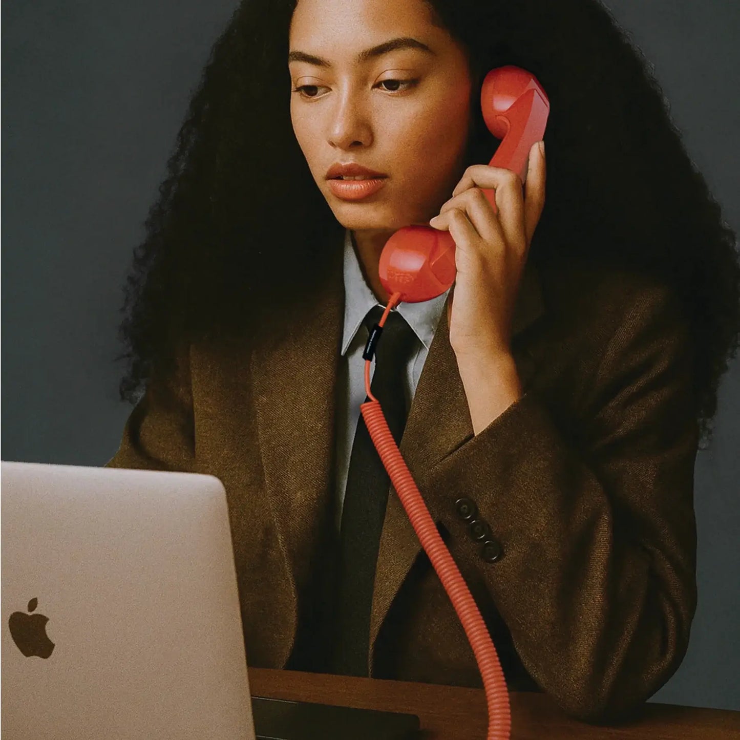 Combiné de téléphone Rouge Alarme Pop Phone de chez Native Union. Branché à un ordinateur avec un câble USB-C.