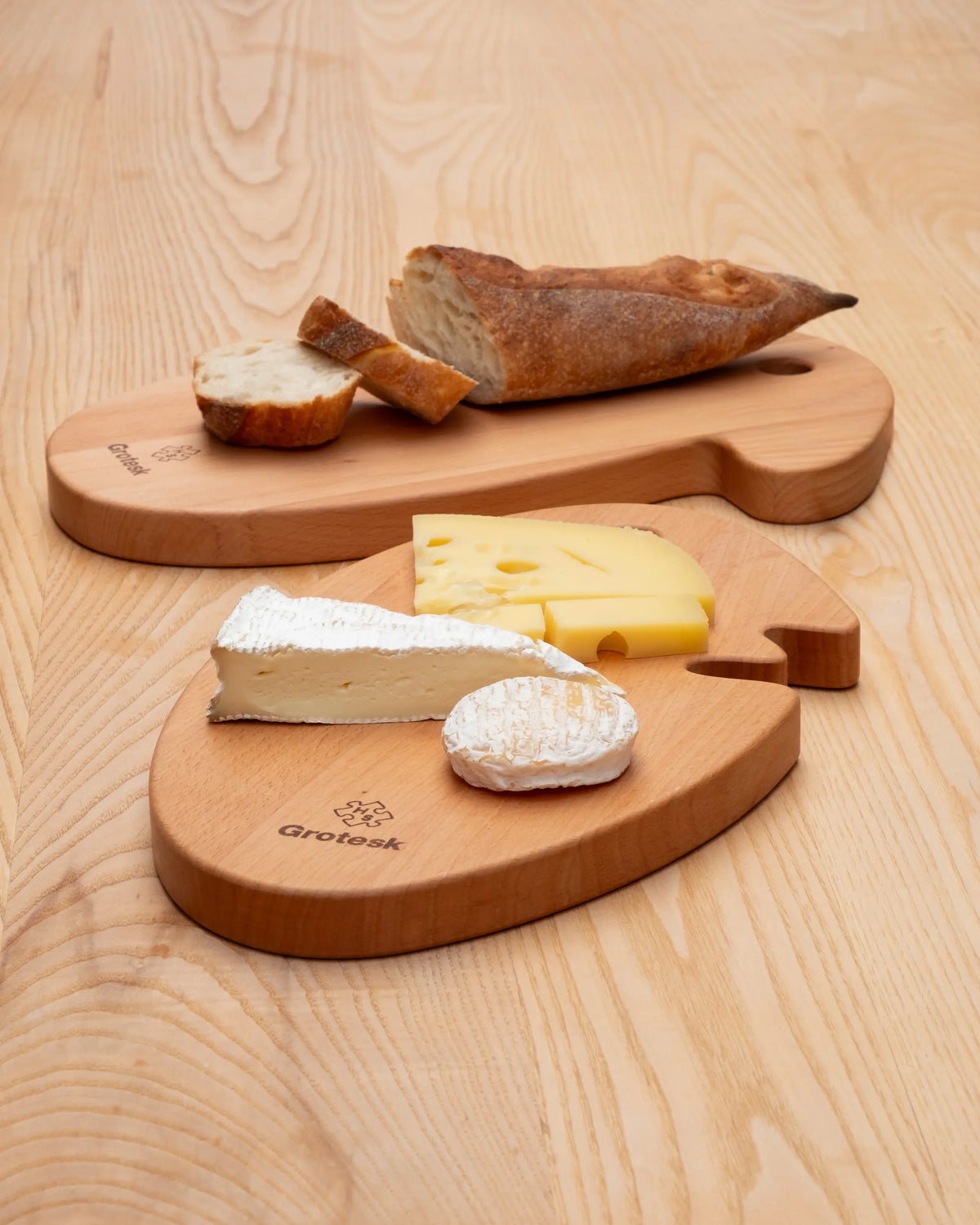  2 modèles  Cheese Head présentées avec du pain et du fromage