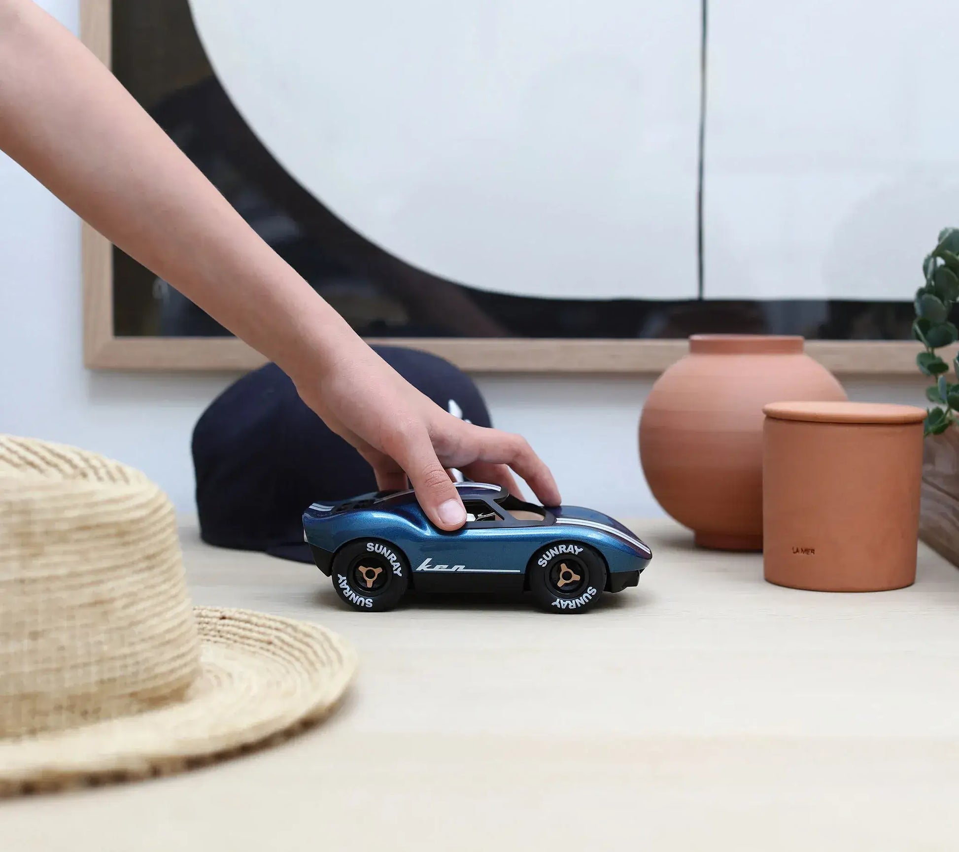 Voiture miniature Playforever Ken Cash bleu nuit et cuivre manipulée à la main