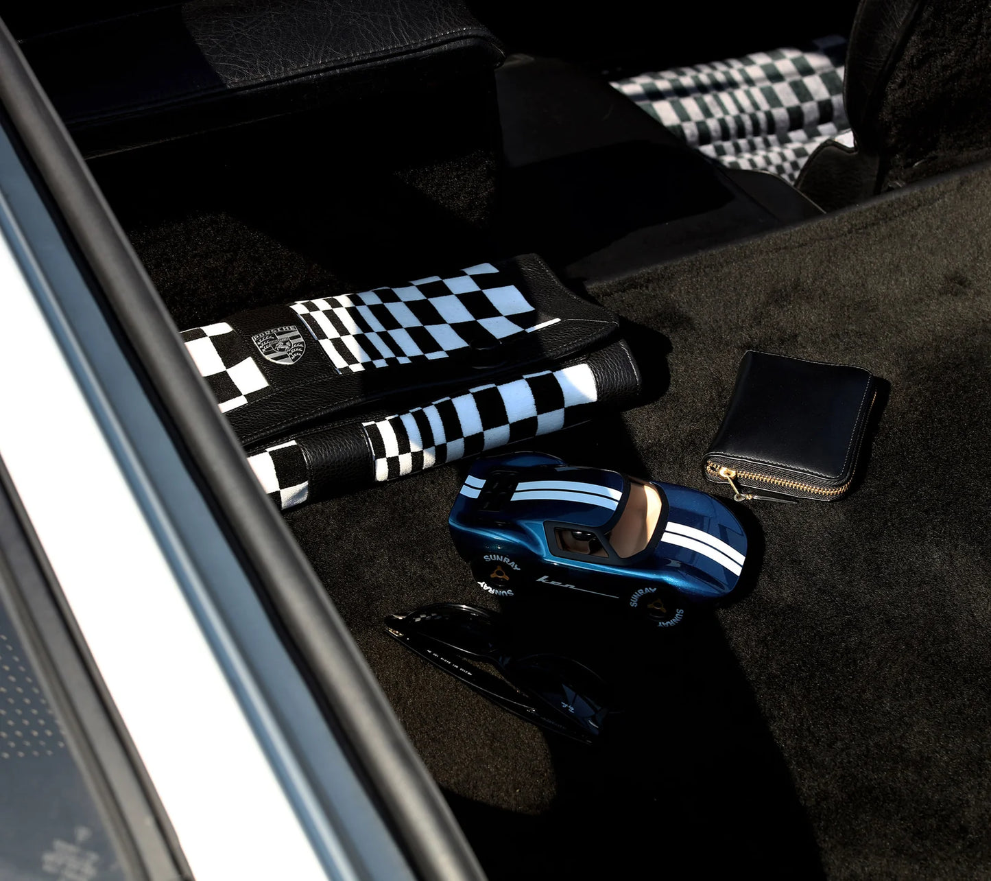 Voiture miniature Playforever Ken Cash bleu nuit et cuivre présentée avec accessoires du quotidien