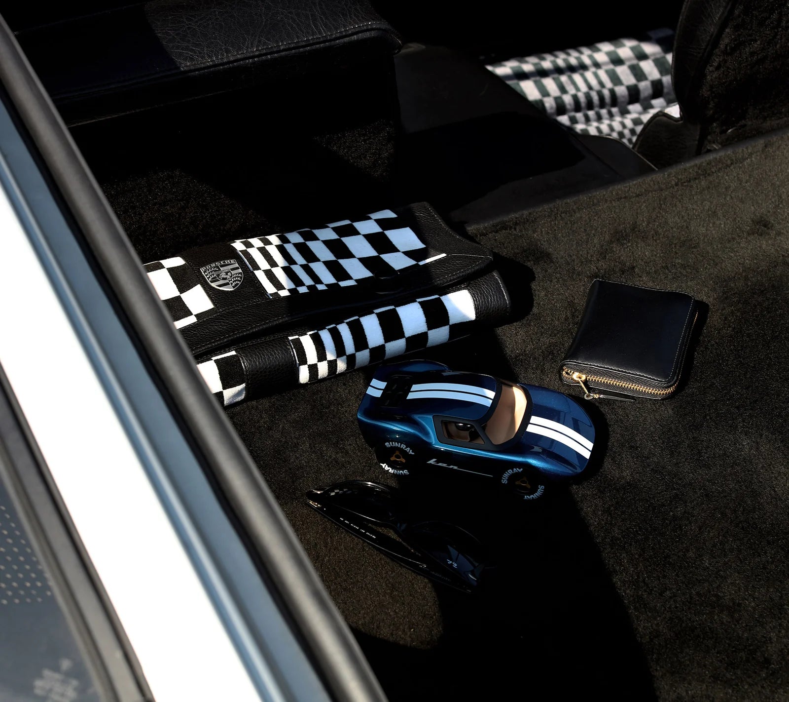 Voiture miniature Playforever Ken Cash bleu nuit et cuivre présentée avec accessoires du quotidien