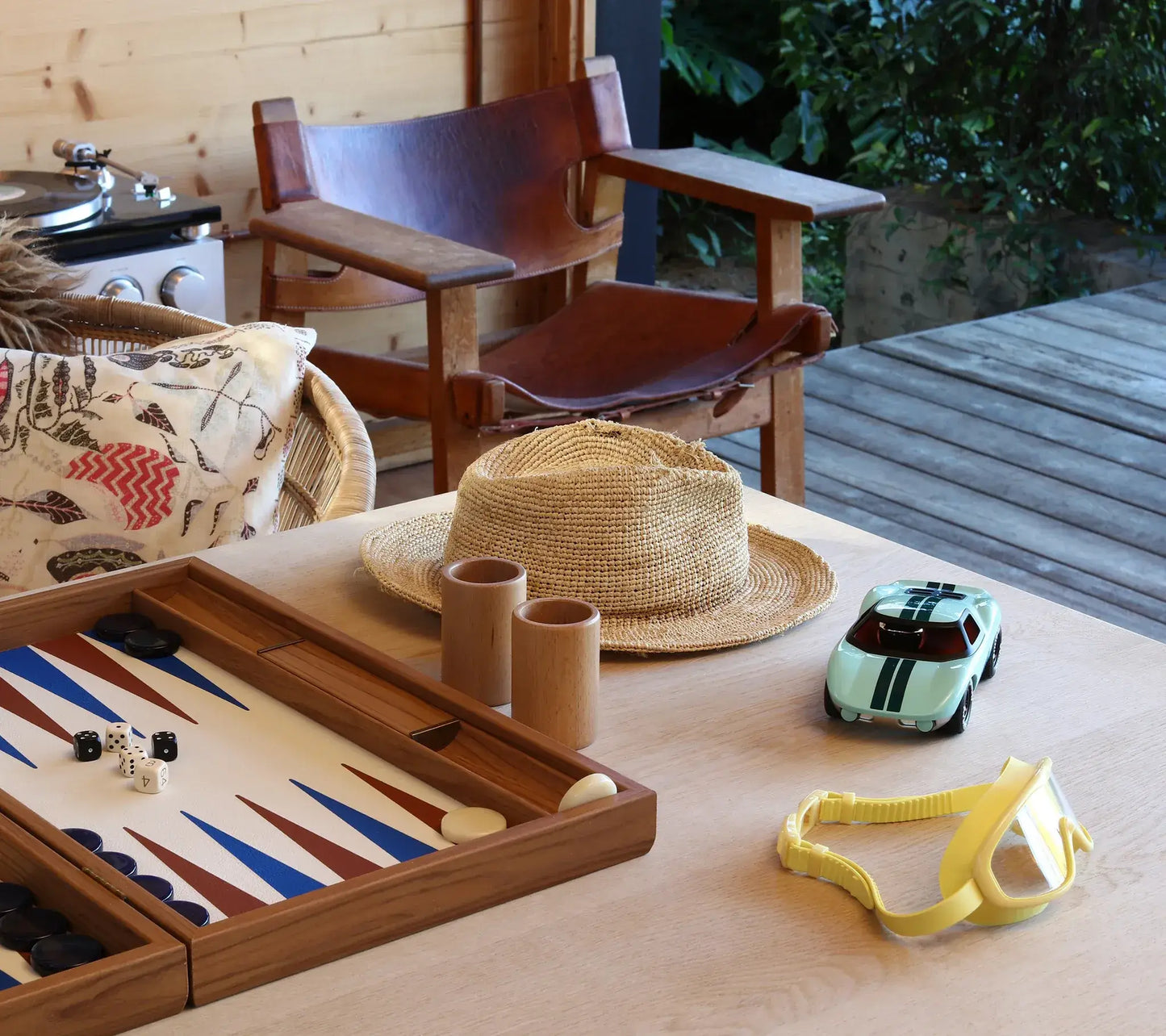 Voiture miniature Playforever Ken Parton turquoise sur une table avec jeu de backgammon
