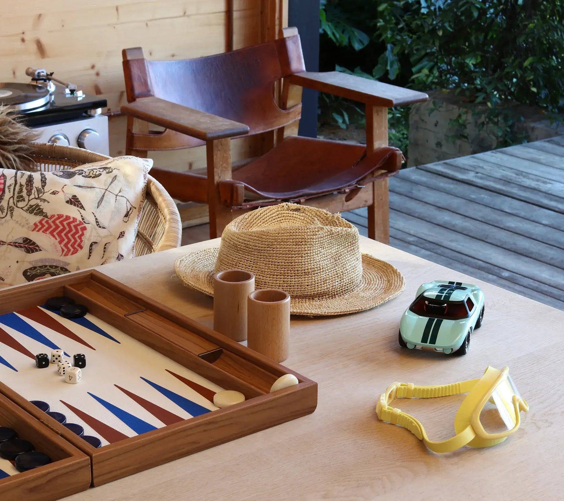 Voiture miniature Playforever Ken Parton turquoise sur une table avec jeu de backgammon