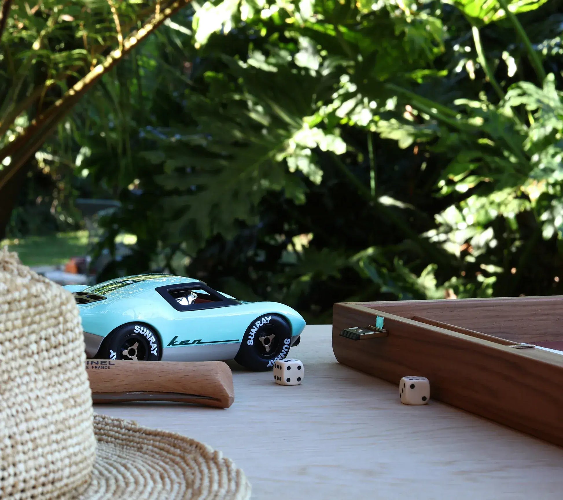 Voiture miniature Playforever Ken Parton turquoise sur une table en extérieur