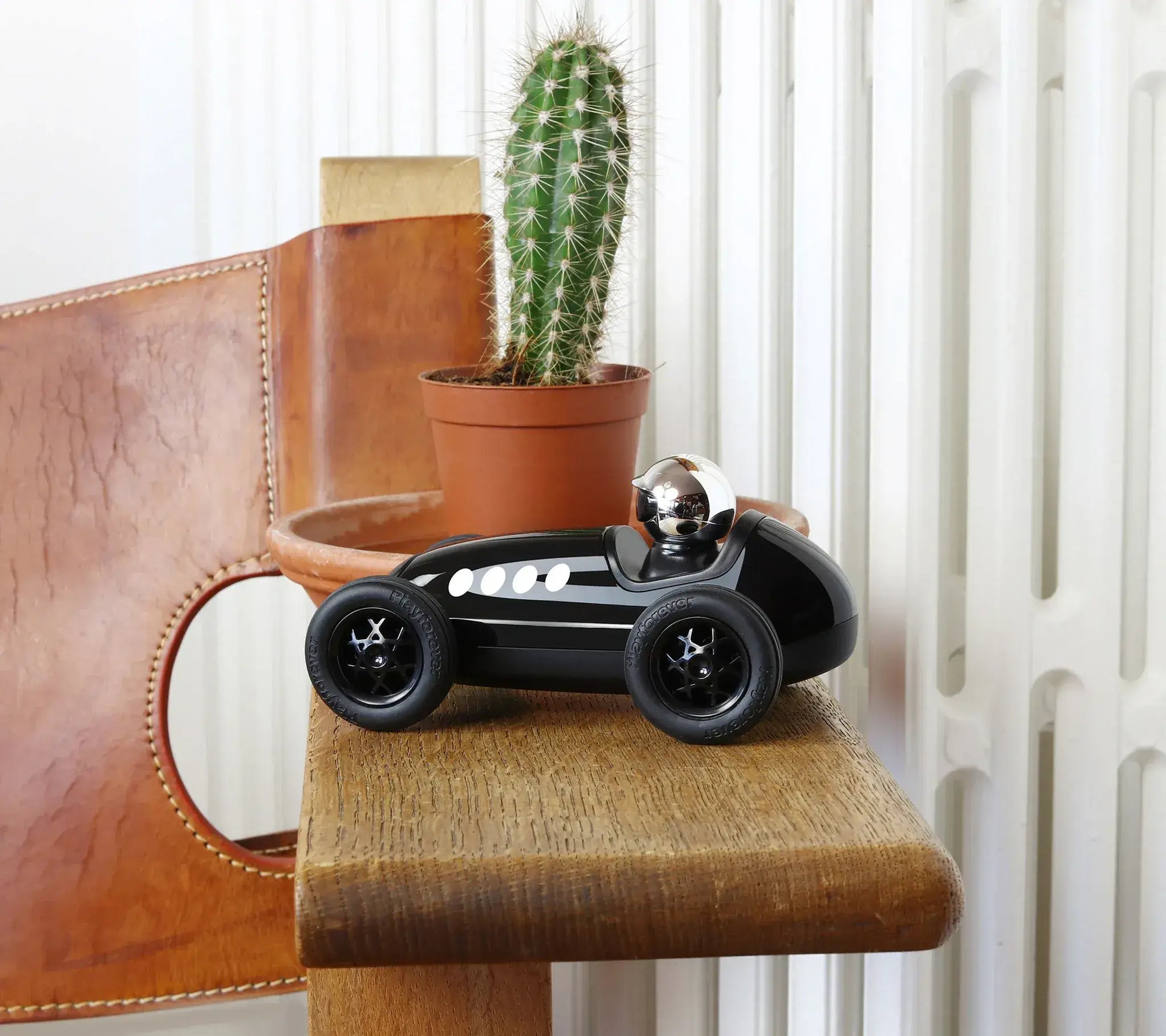 Voiture miniature Playforever Loretino Verona noire sur table en bois