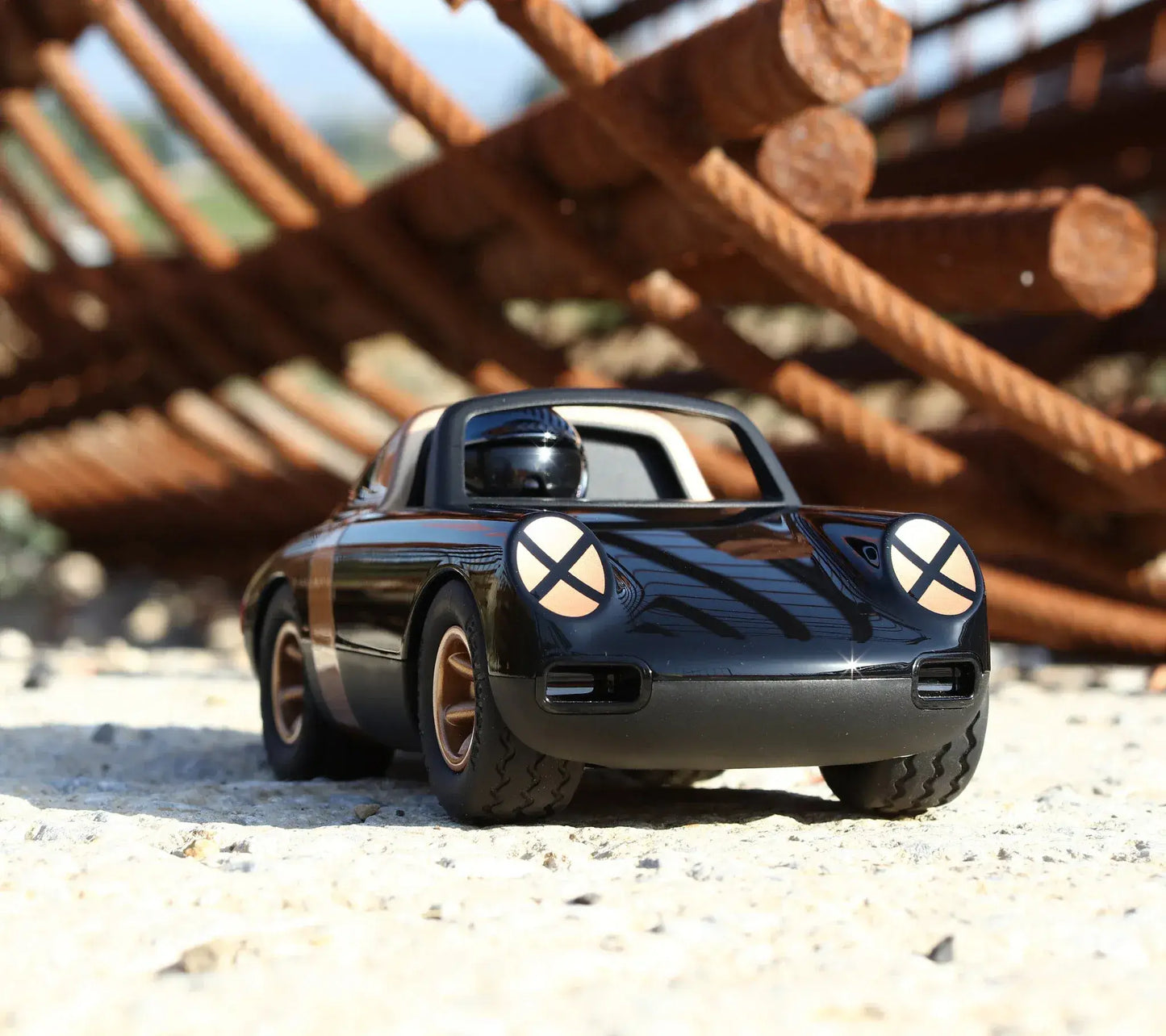 Voiture miniature Playforever Luft Crow noire et or dans un décor industriel