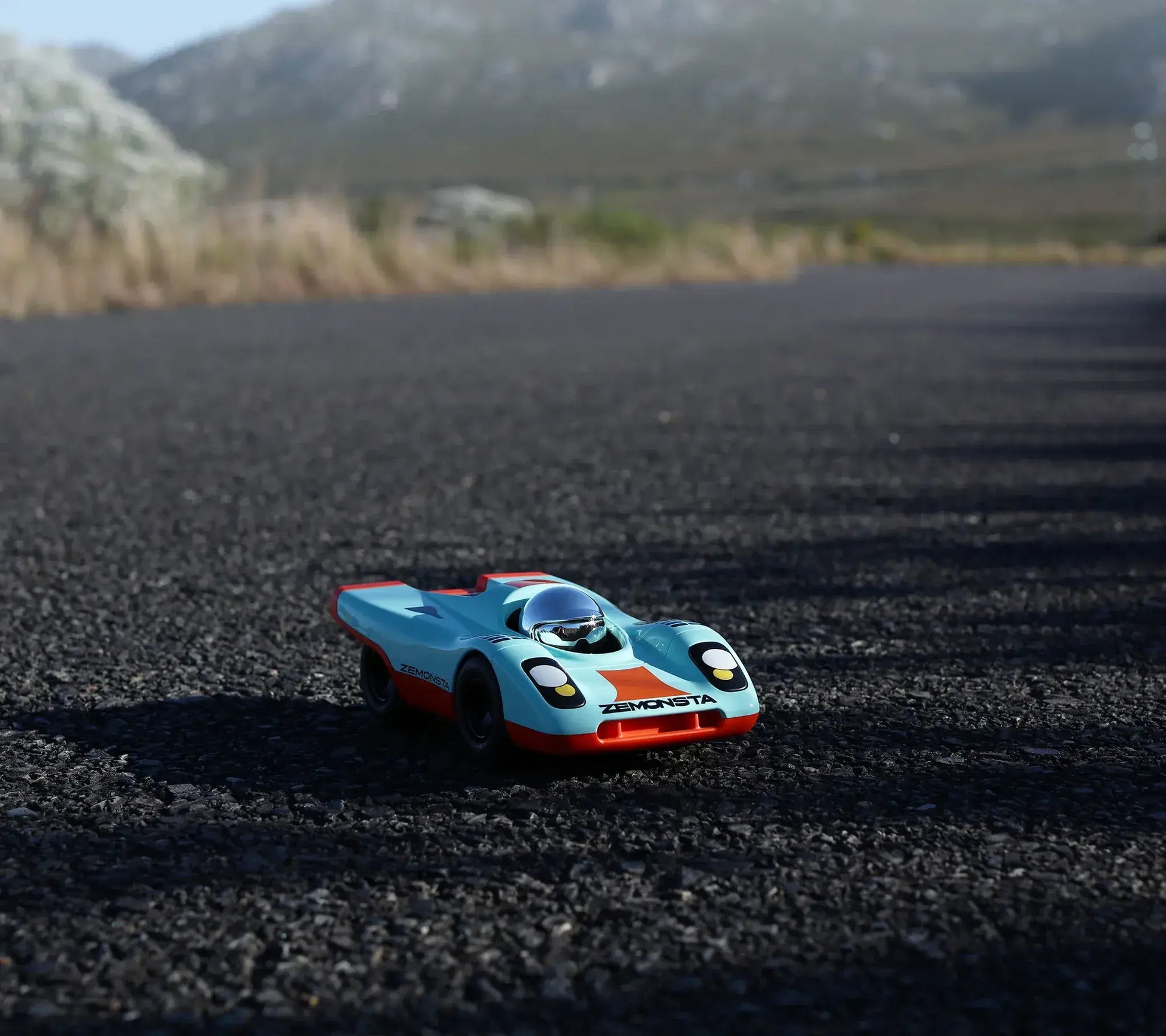 Voiture Playforever Zemonsta Klaus turquoise sur une route de montagne