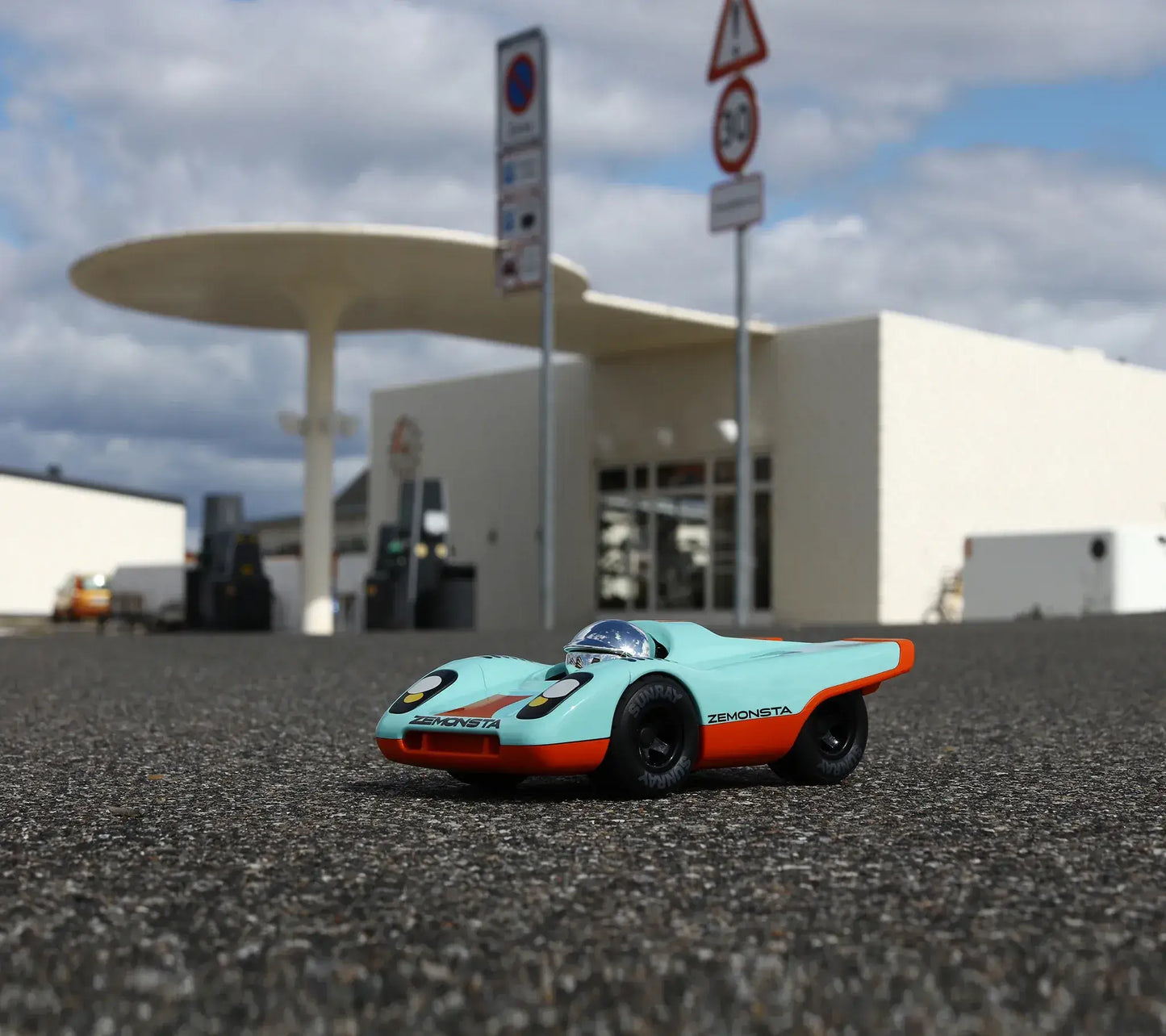 Voiture Playforever Zemonsta Klaus devant une station-service rétro