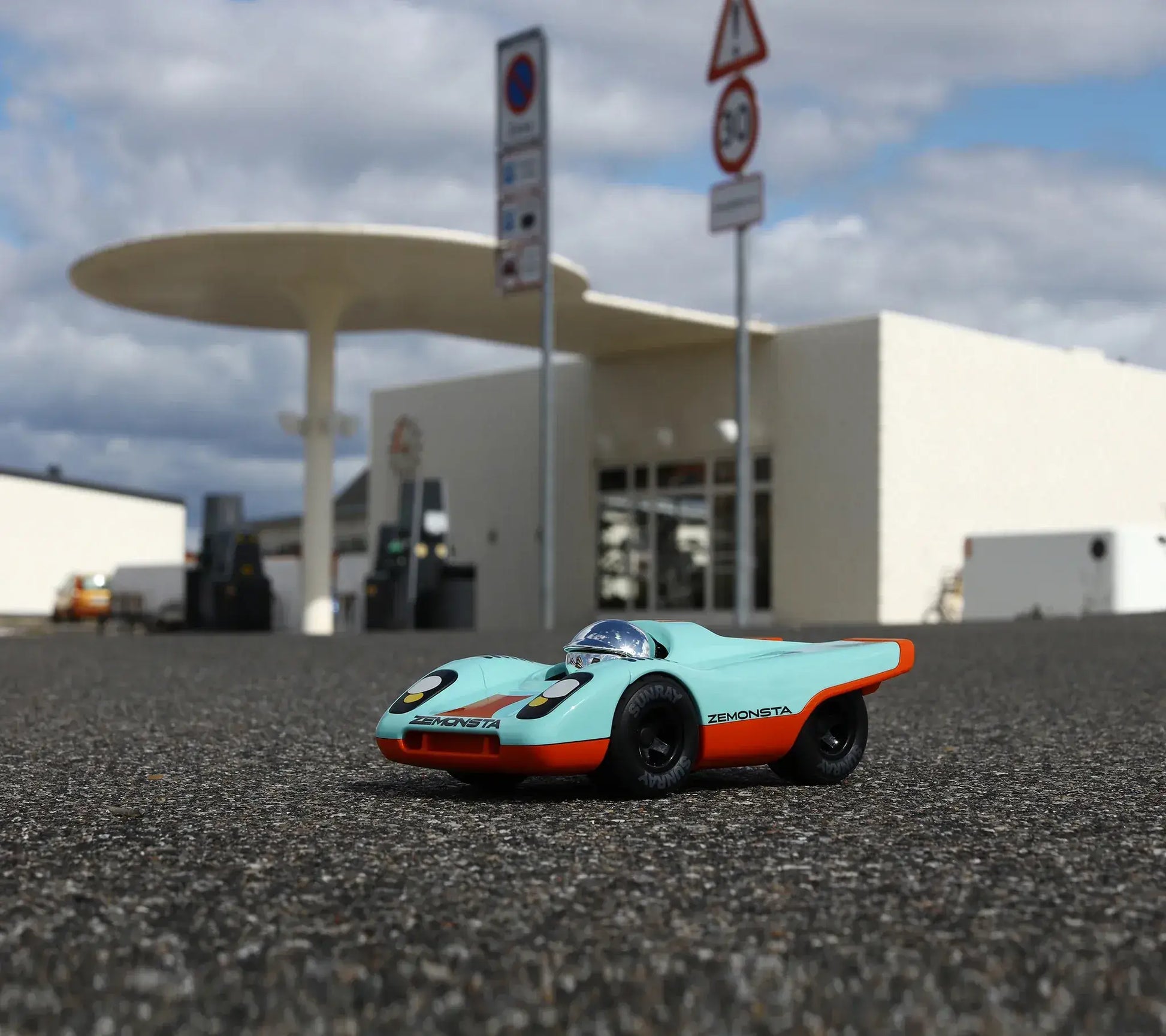 Voiture Playforever Zemonsta Klaus devant une station-service rétro