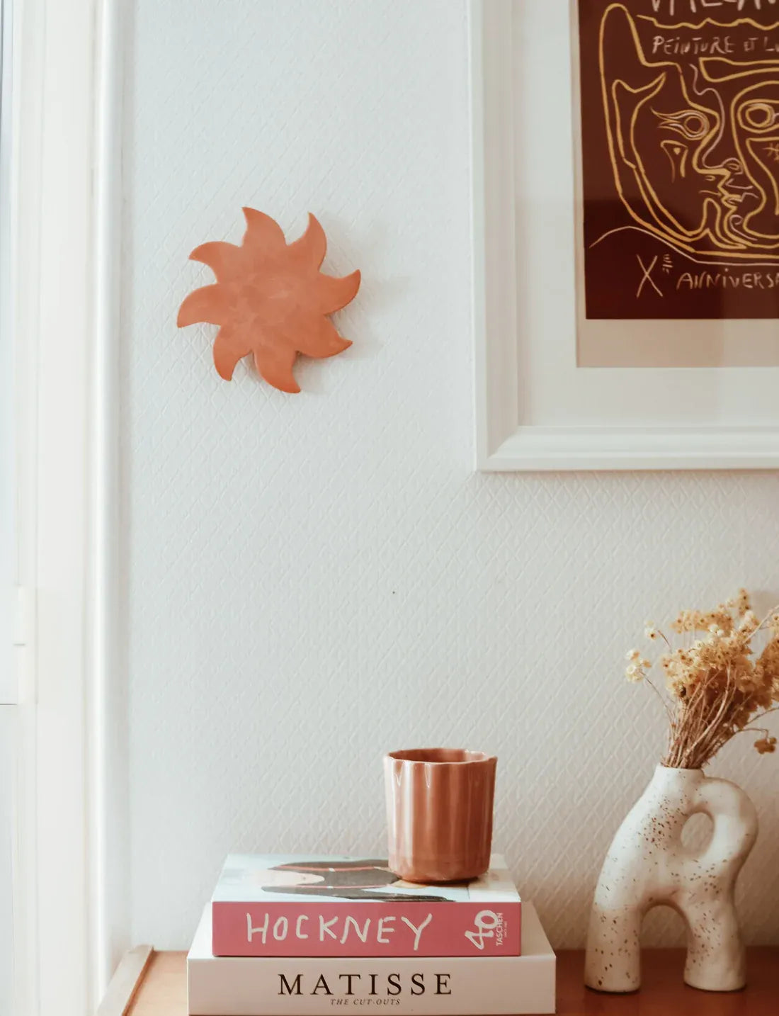 Soleil mural terracotta accroché au mur