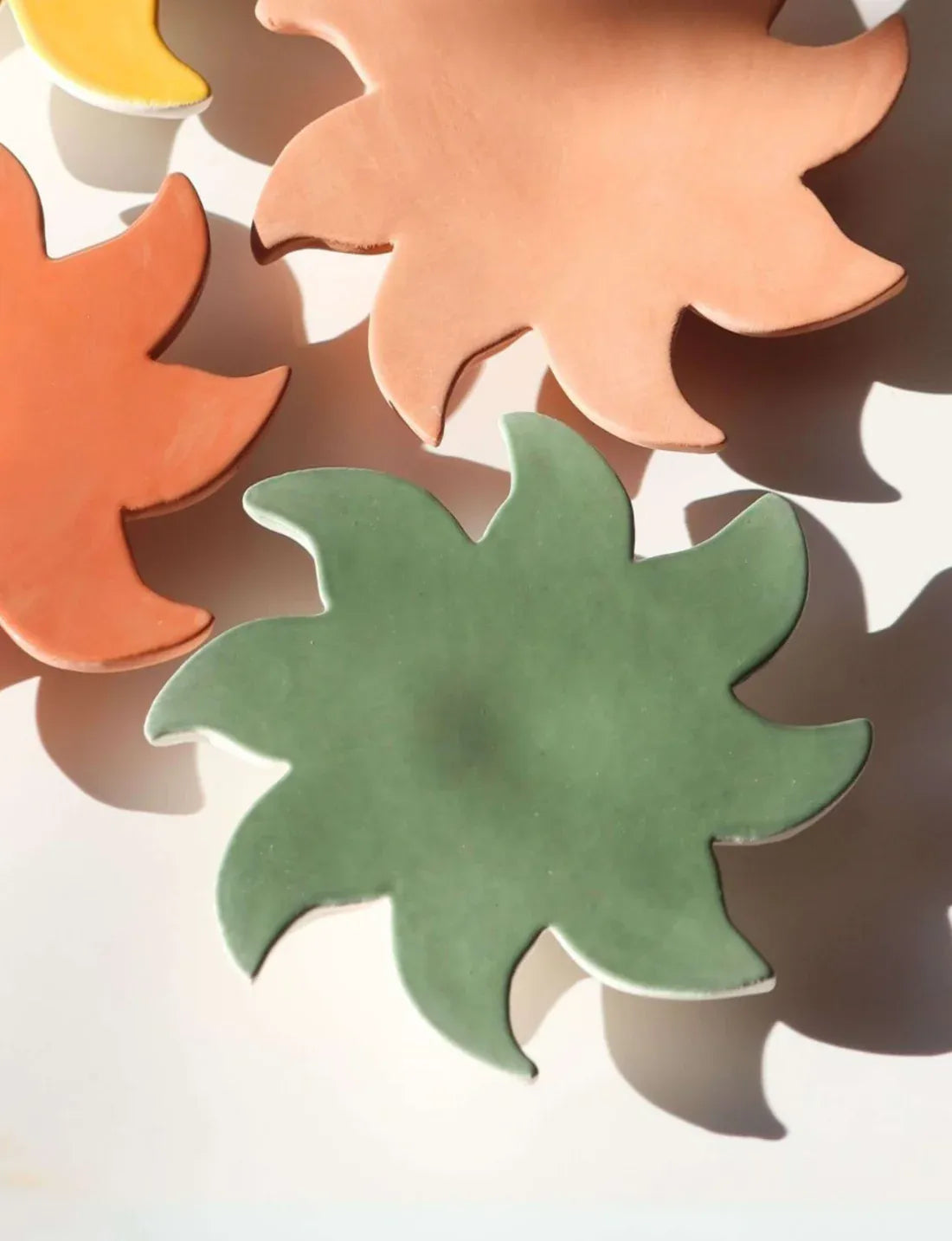 Soleil mural vert en céramique Maison Béata avec ombre portée