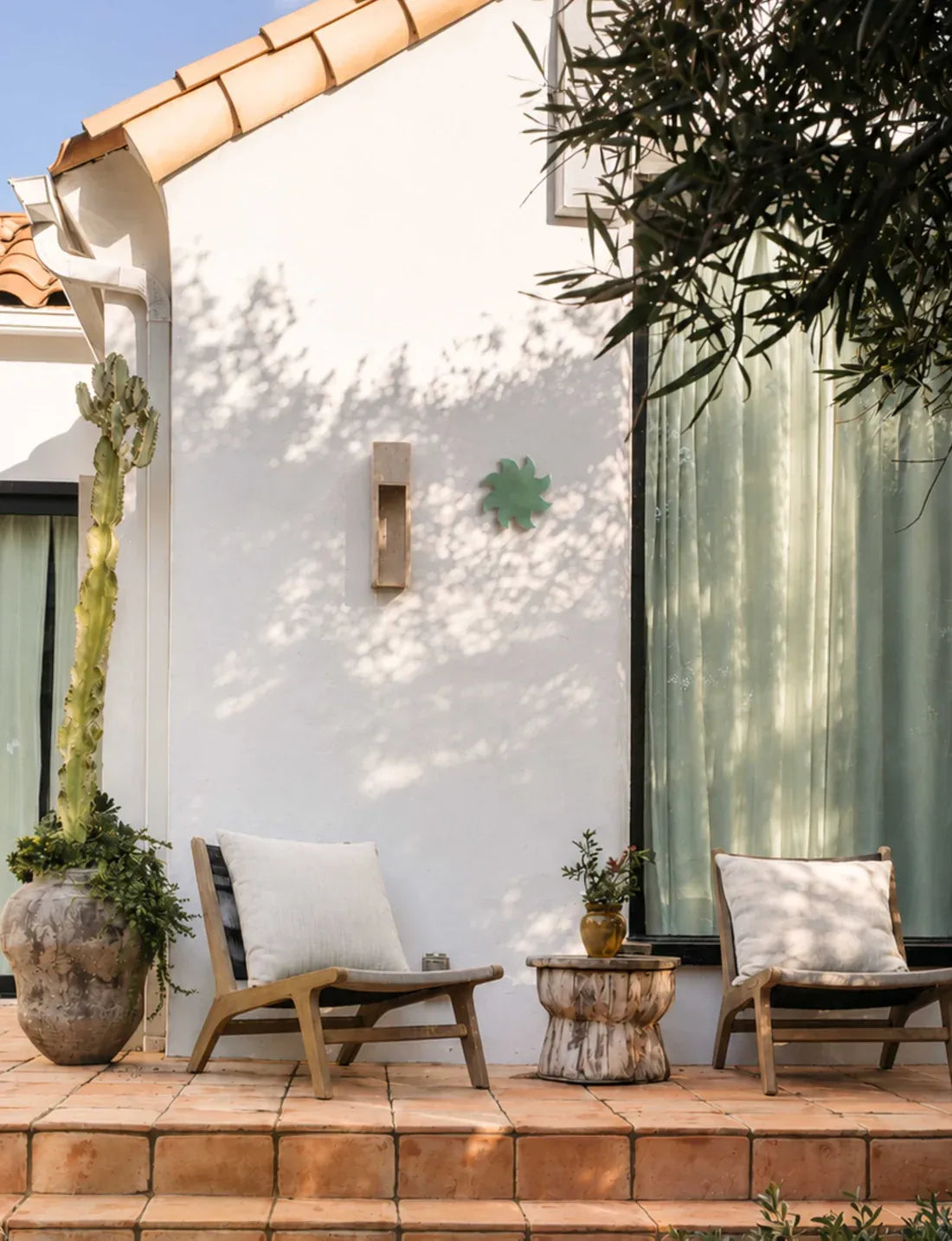 Soleil mural vert en céramique Maison Béata sur une terrasse