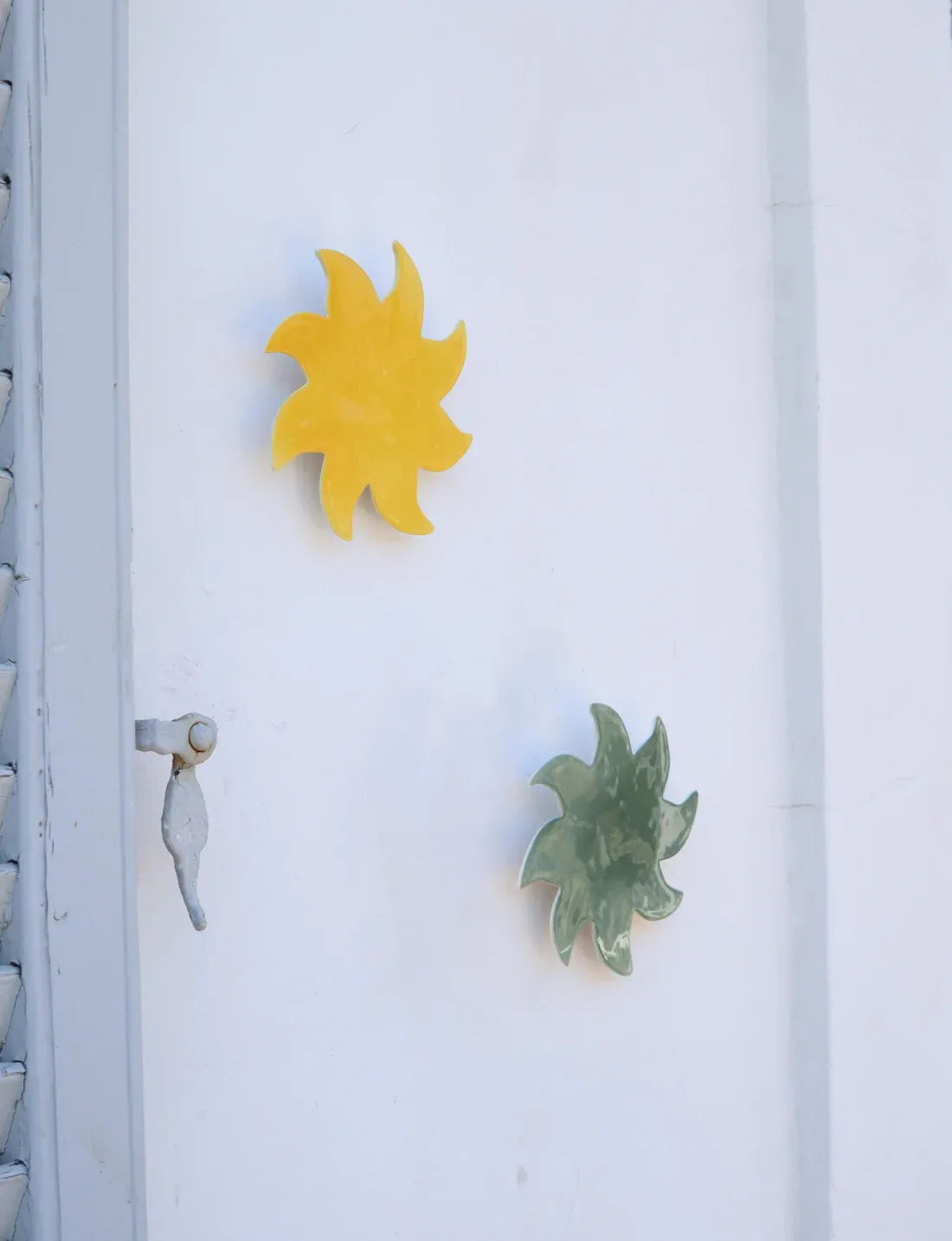 Soleils muraux jaune et vert en céramique Maison Béata sur une porte