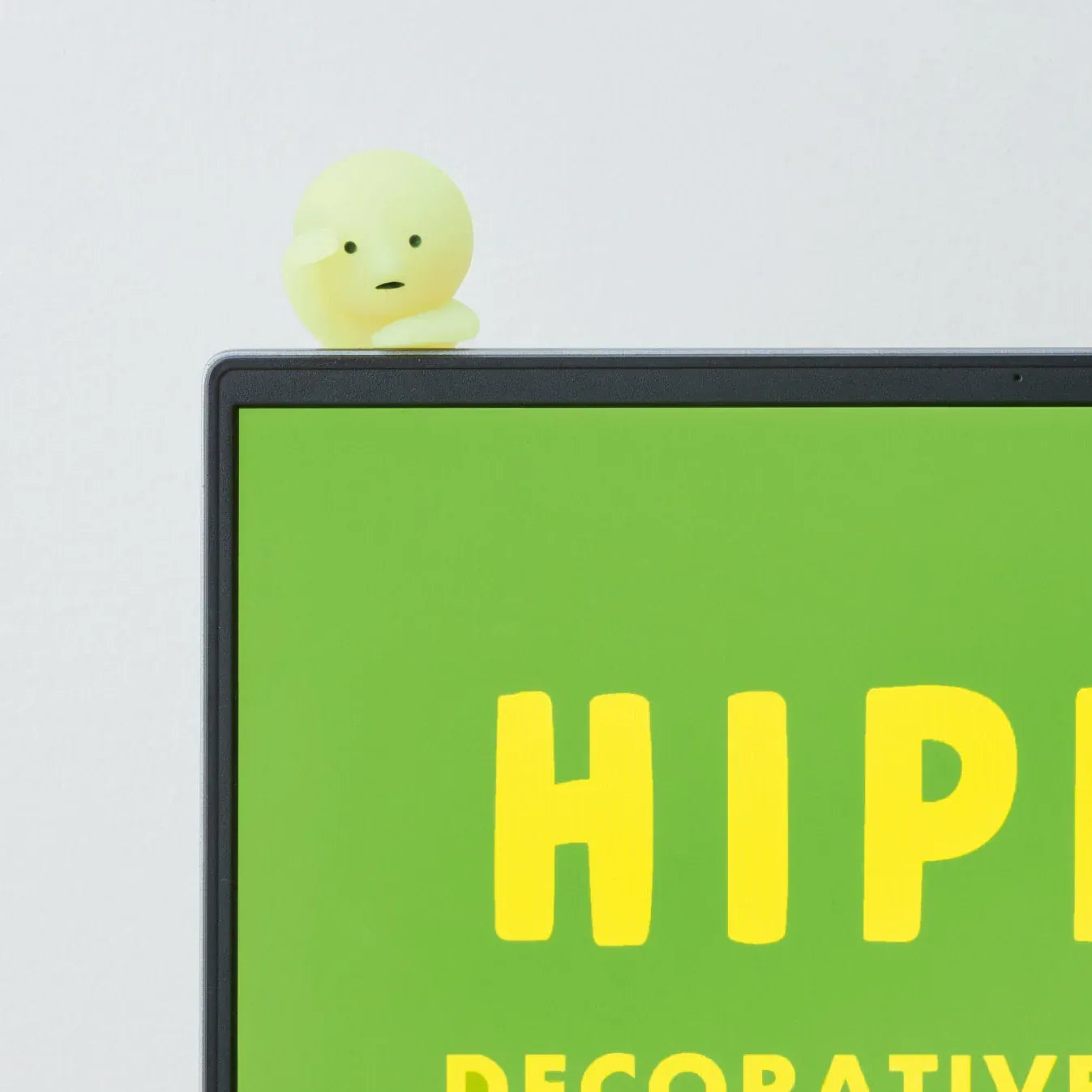Figurine Smiski Hippers regardant au loin depuis un ordinateur