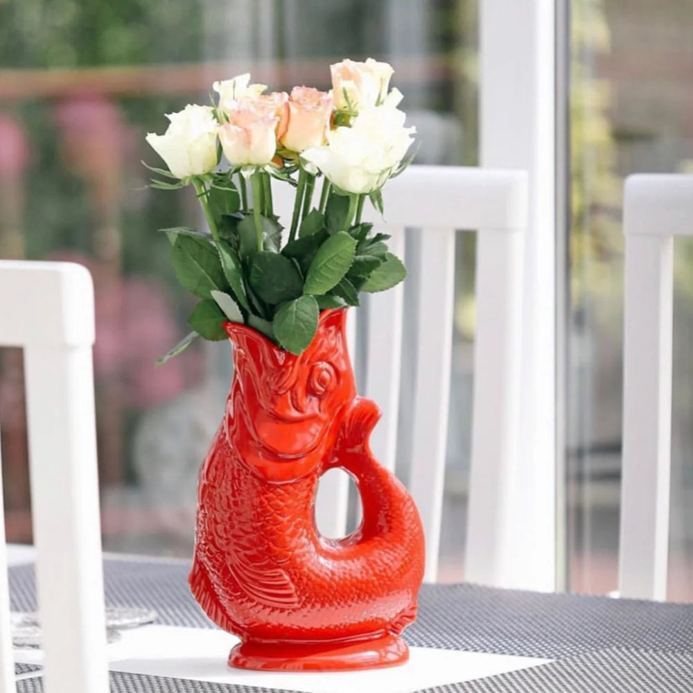 Carafe Glouglou rouge utilisée comme vase avec bouquet de fleurs