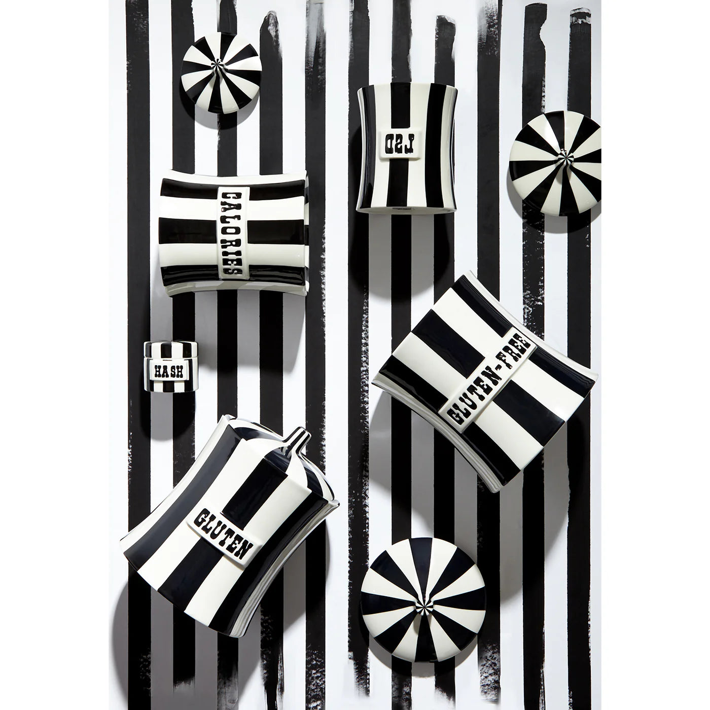 Collection "Vice" de boîtes en porcelaine Jonathan Adler - Rayures noires et blanches - présentées sur fond rayé noir et blanc