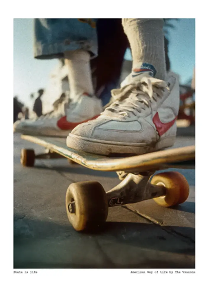 "Skate is Life - American Way Of Life" plan rapproché d'un skateboard monté par un skateur