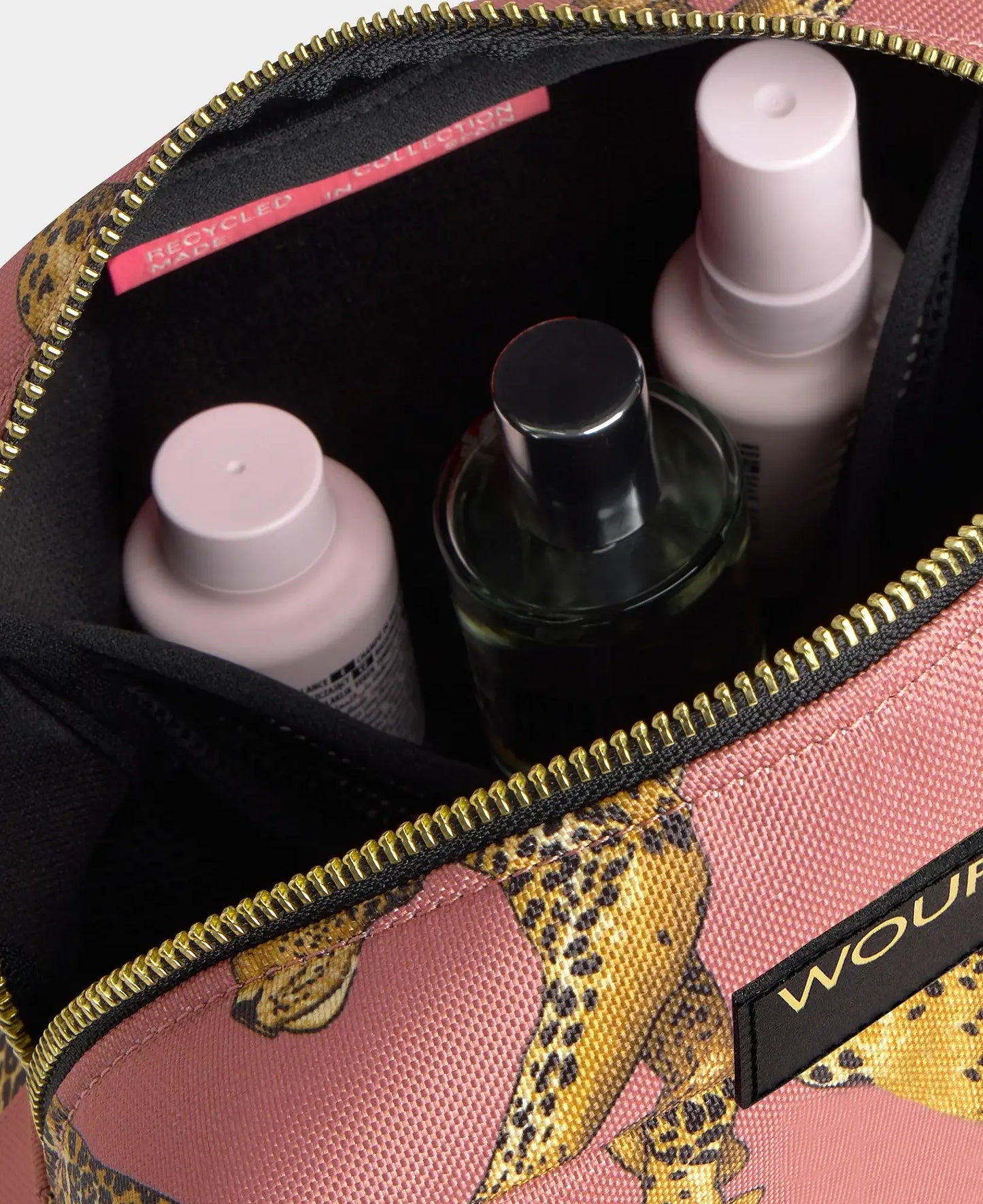 Vue intérieure de la trousse de toilette Wouf Blush Léopard avec quelques produits de beauté