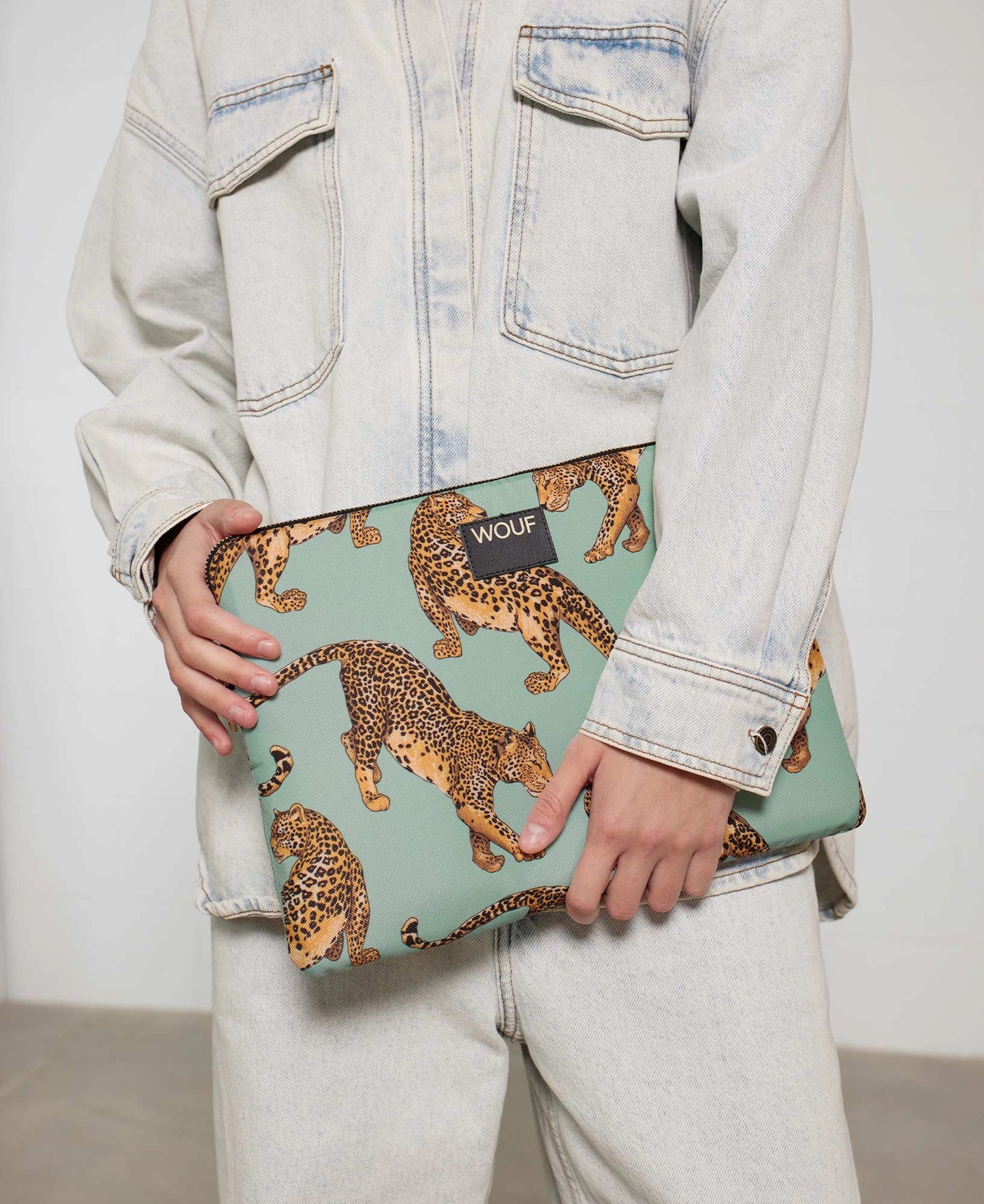 Housse de protection Emerald Leopard de chez Wouf dans les mains d'un mannequin