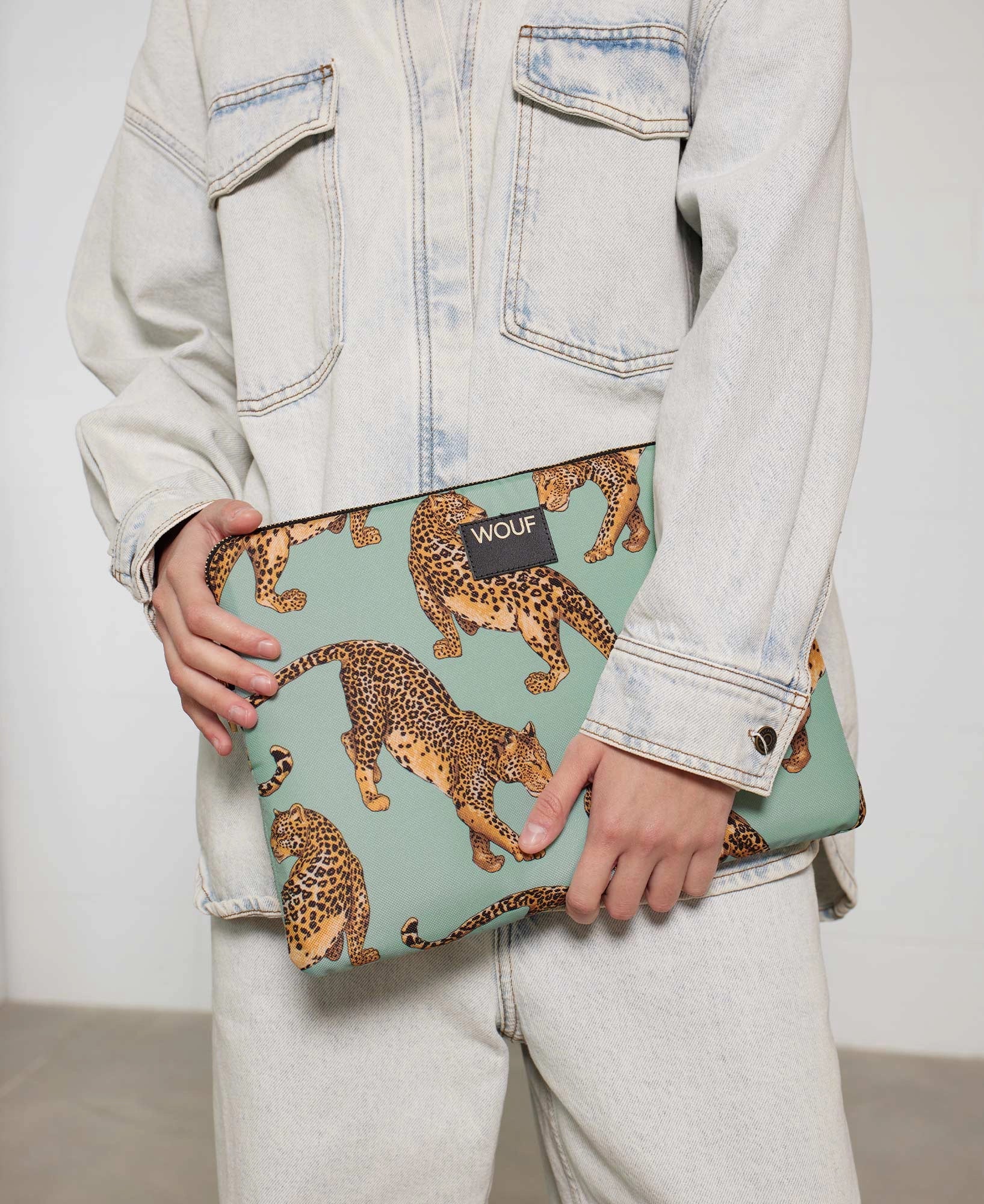 Housse de protection Emerald Leopard de chez Wouf dans les mains d'un mannequin