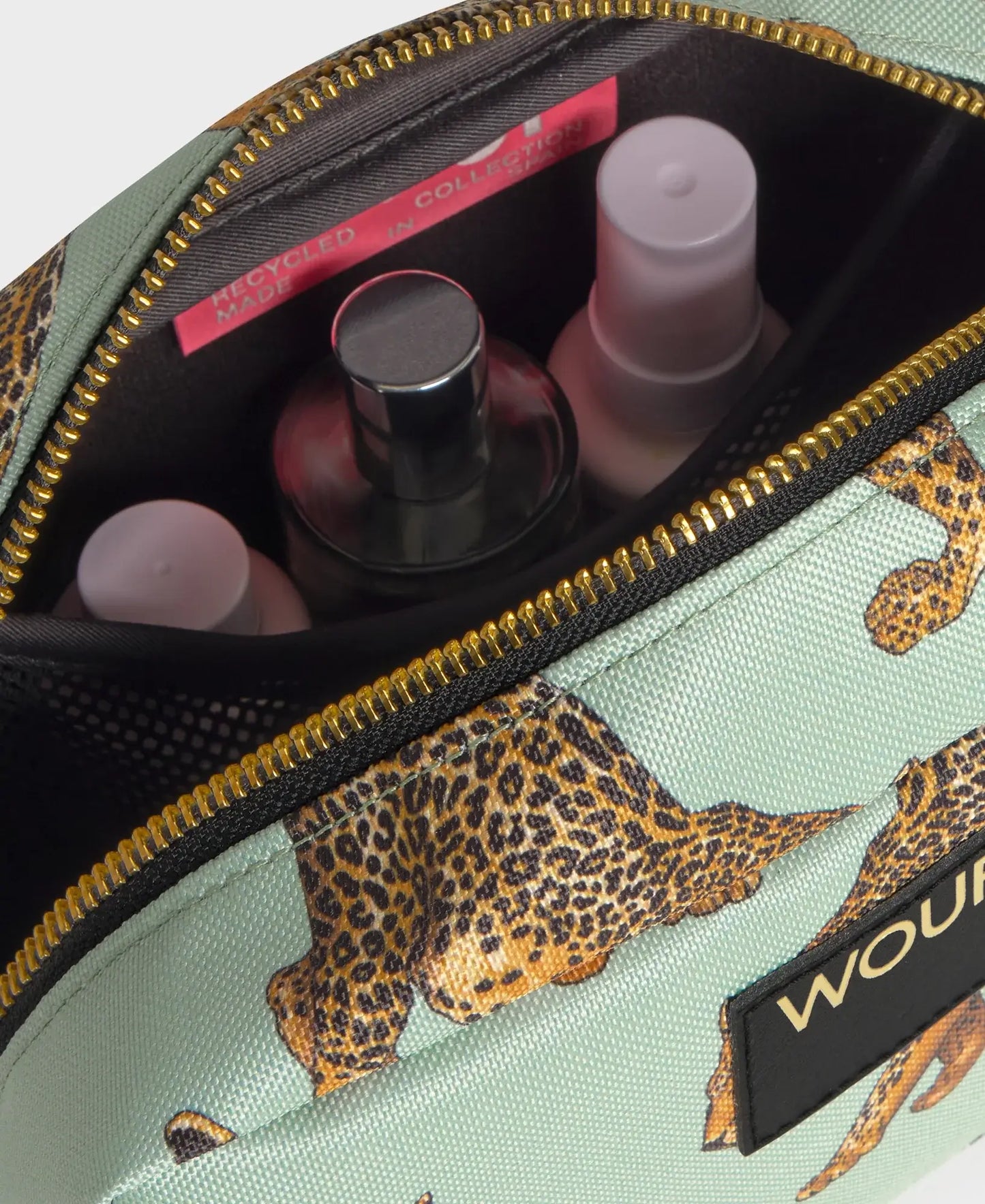 Trousse de toilette Emerald Leopard de chez Wouf ouverte avec des produits de beauté