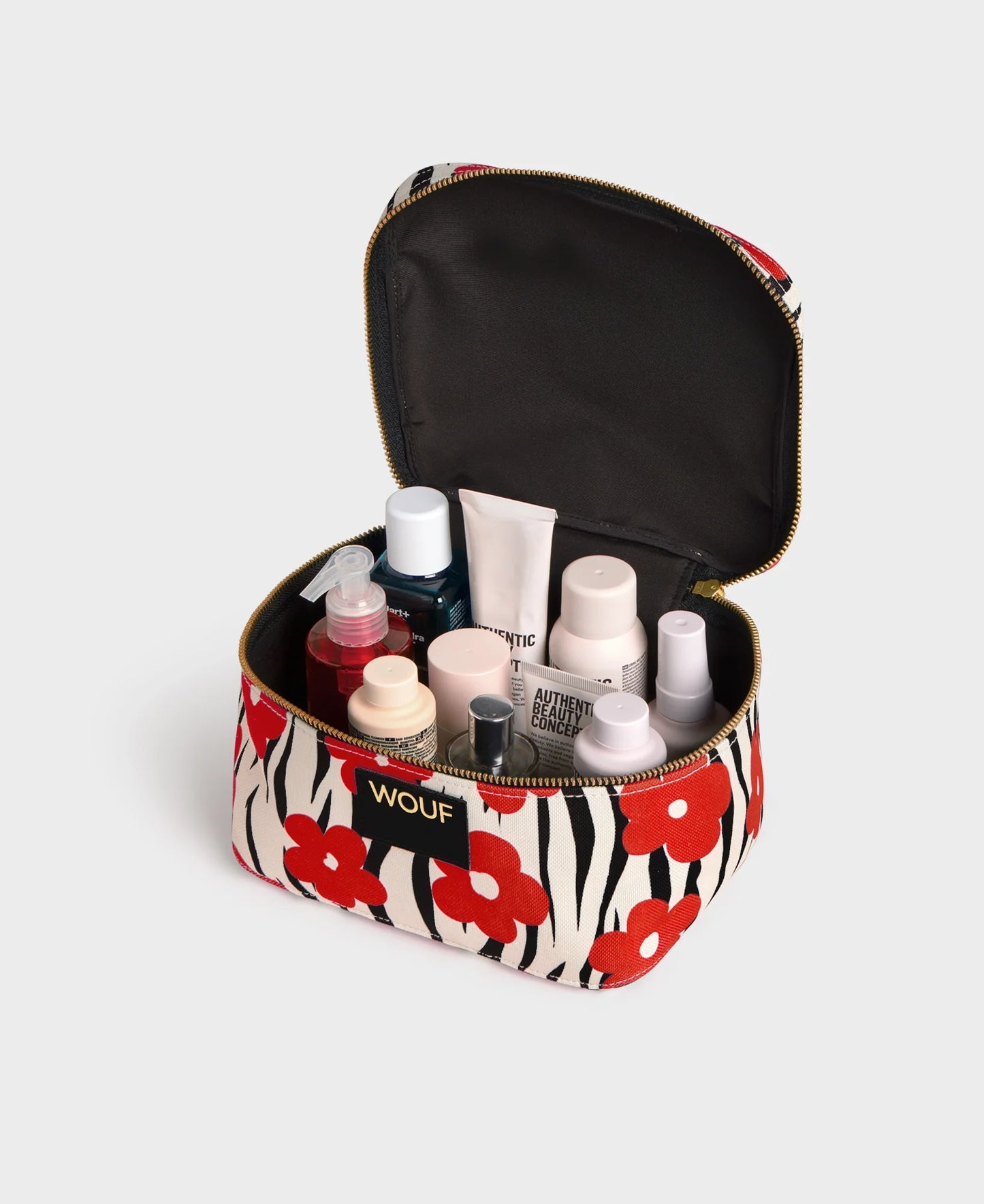 Trousse de toilette Vanity Wildflower de chez Wouf ouverte avec des produits de beauté et du maquillage
